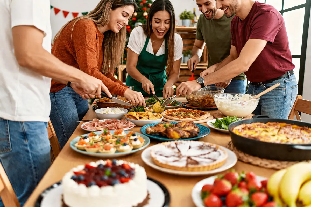 Amis préparant un buffet festif, idée de repas du 31 décembre entre amis conviviale et gourmande