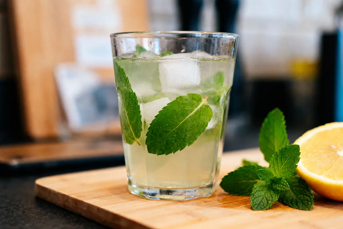 Verre de sirop de menthe sans sucre avec glace et citron sur planche en bois