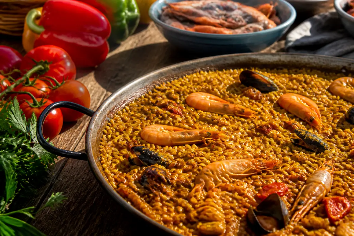 Grande paella garnie de fruits de mer et légumes colorés, avec riz à paella parfait